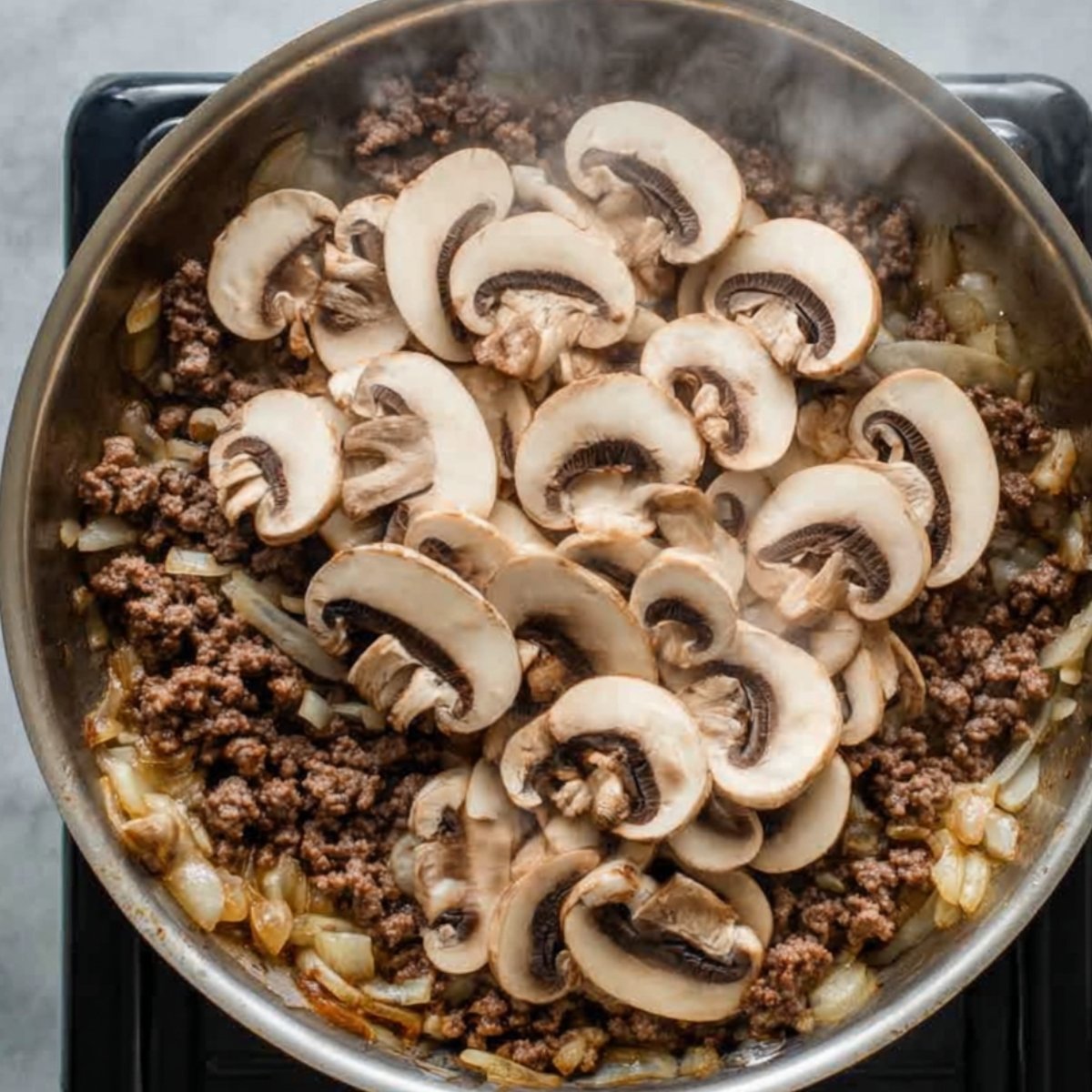 Add the sliced mushrooms and sauté for another 5 minutes, until they're softened and starting to brown. If the mushrooms release excess liquid, just let it evaporate. This concentrates their flavor and keeps your sauce from getting watery.