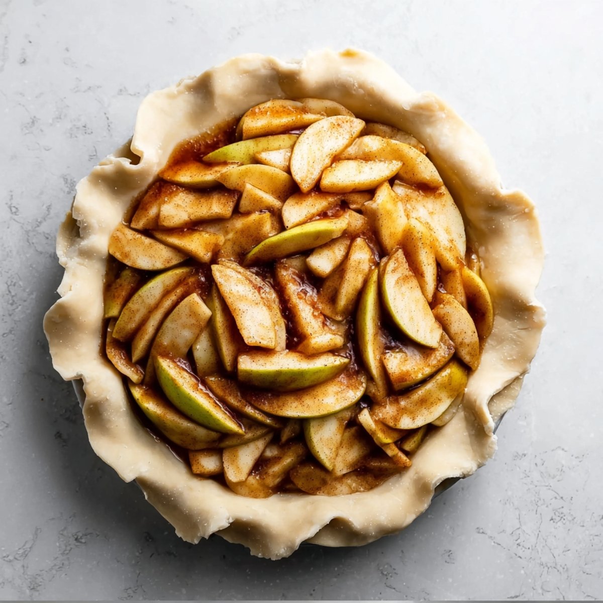 piling it high—it may look like too much, but the apples will cook down. Roll out the second disc of dough into a 12-inch circle. Use a sharp knife or pizza cutter to slice it into 1-inch-wide strips. Weave the strips over and under to create a lattice pattern on top. Trim any extra dough and pinch the edges to seal everything together.