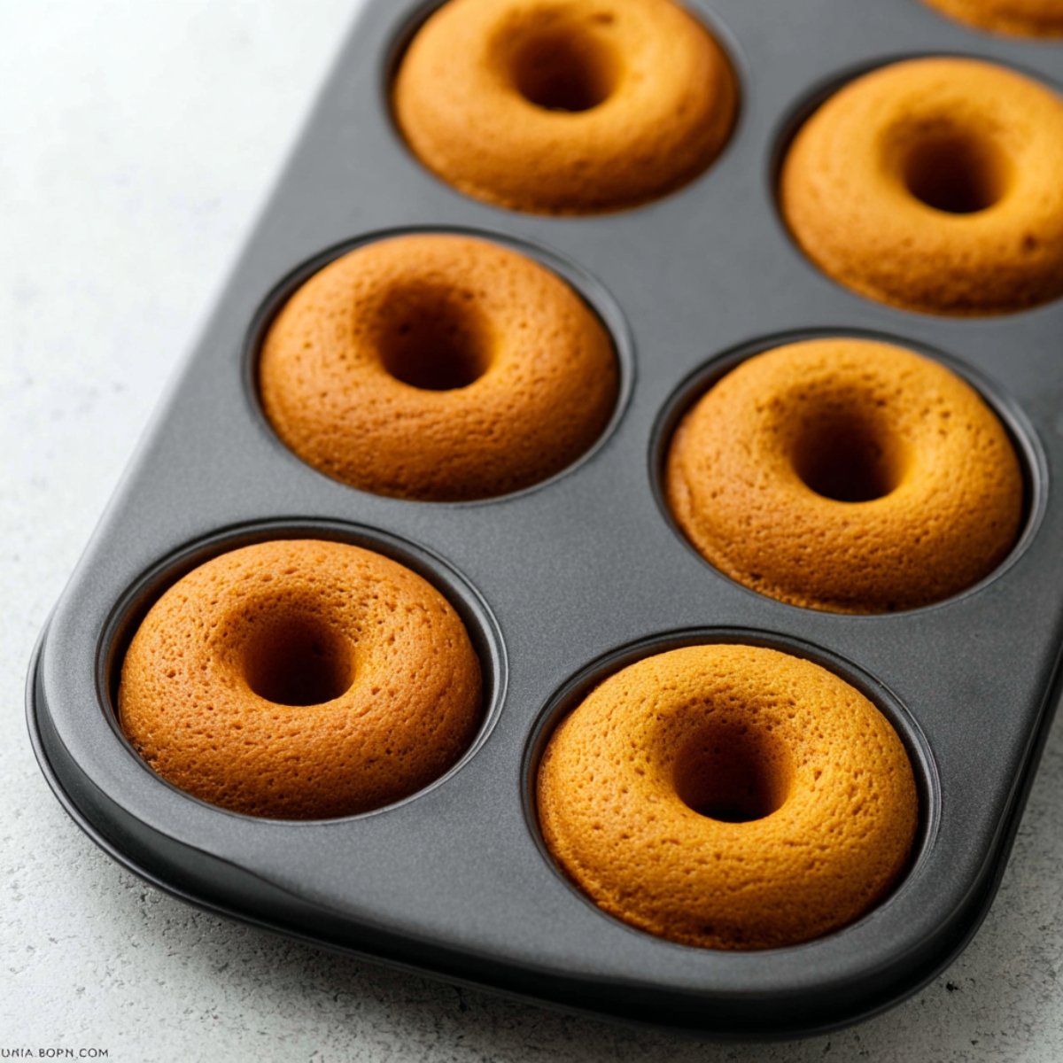 Bake for 10 to 11 minutes, or until the edges and tops are lightly golden. To test doneness, gently press your finger into the top of a donut. If it springs back, they're ready. For mini donuts, bake for 8 to 9 minutes.