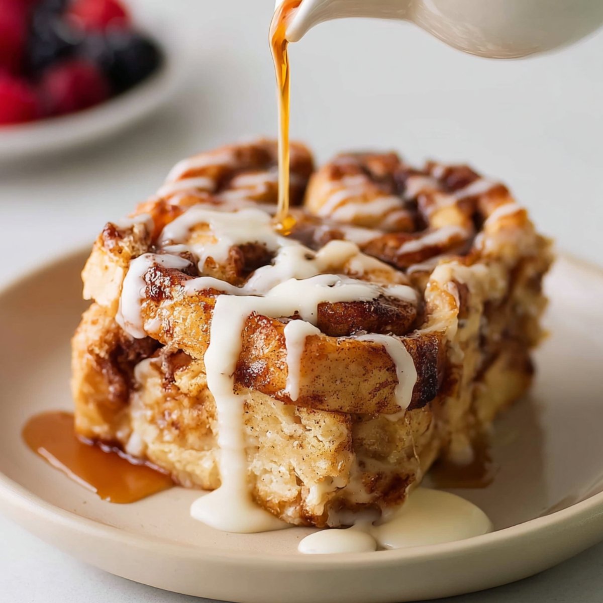 Cinnamon Roll French Toast with icing and syrup being drizzled on top.