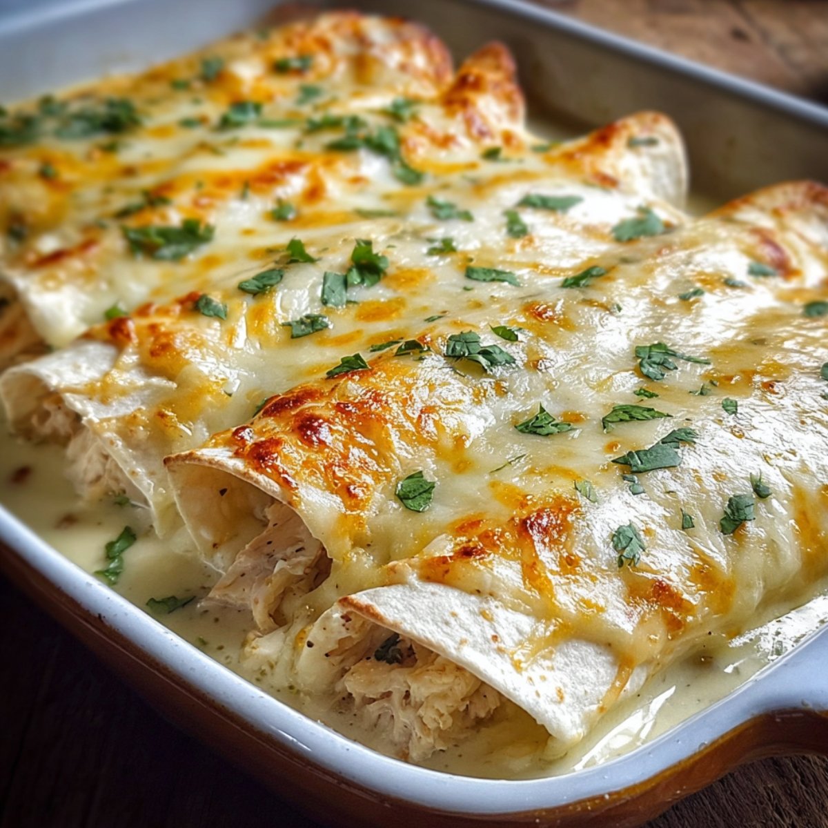 Homemade White Chicken Enchilada topped with melted cheese, cilantro, and diced tomatoes in a serving dish.