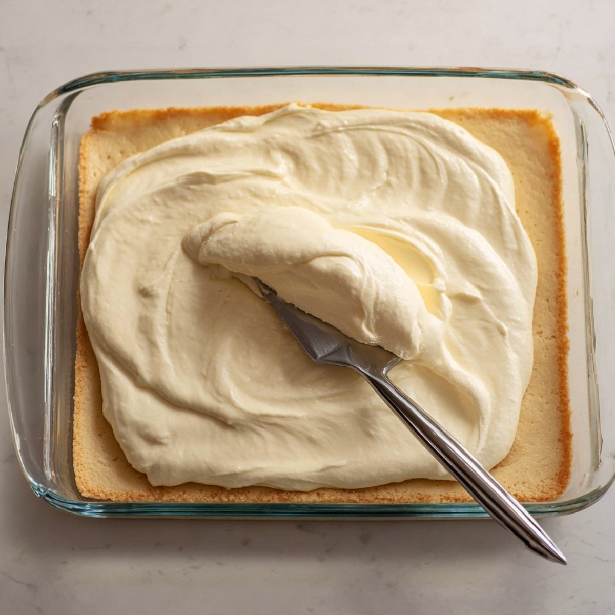 In a mixing bowl, combine the softened cream cheese, sugar, egg, and vanilla. Beat it with a hand mixer or stand mixer until it's completely smooth. No lumps. This takes about a minute or two. Pour this creamy cinnamon cheesecake mixture over the crust and spread it out evenly with a spatula.