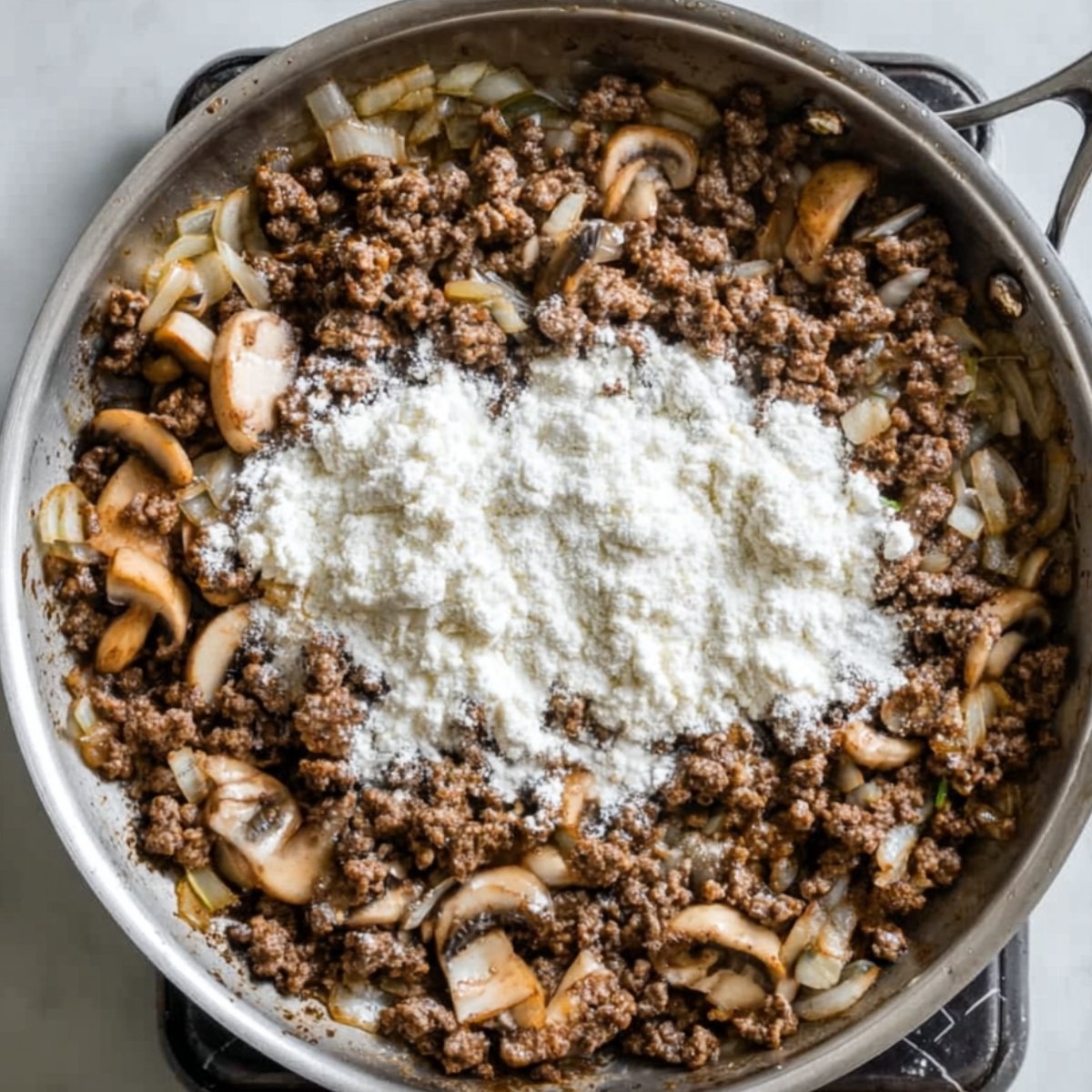 Sprinkle the flour over everything and stir it in until it's fully incorporated. Make sure to break up any lumps. This is going to thicken your sauce and give it that silky texture.
