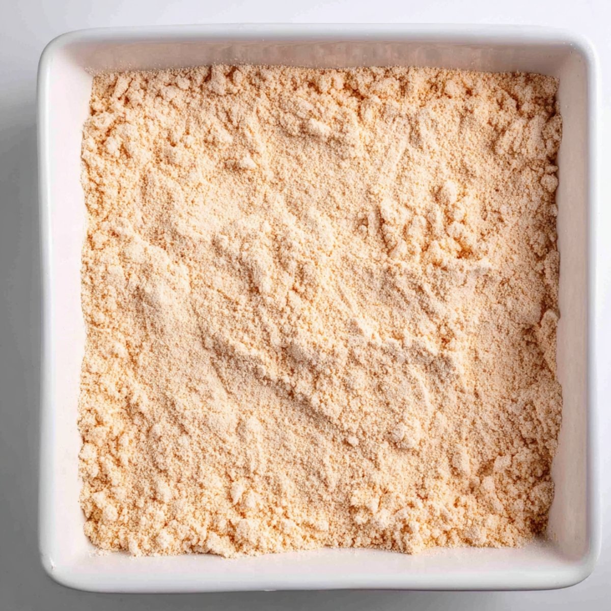 Assembling the pecan pie dump cake in a baking dish.
