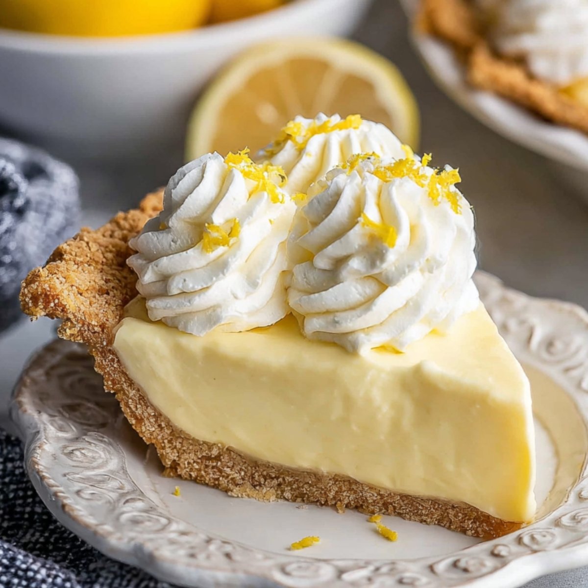 Creamy Lemon Cream Pie with a golden, flaky crust and a smooth, creamy filling, sitting on a white plate.