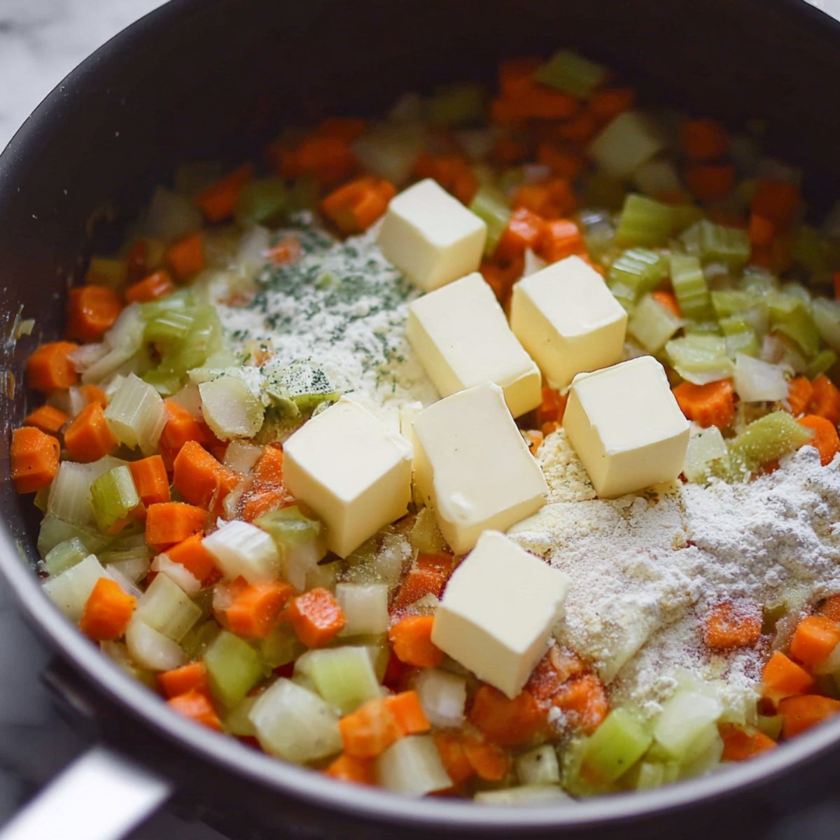 A skillet with sautéed vegetables, butter, and flour, forming a roux for a creamy base.