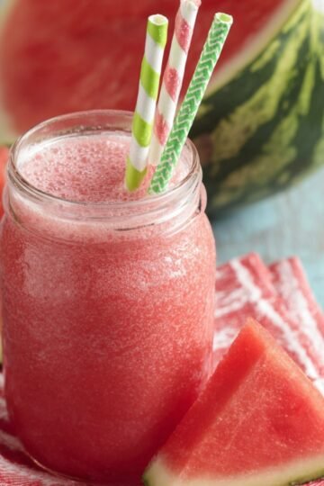 Watermelon Juice with two straws, surrounded by watermelon slices.